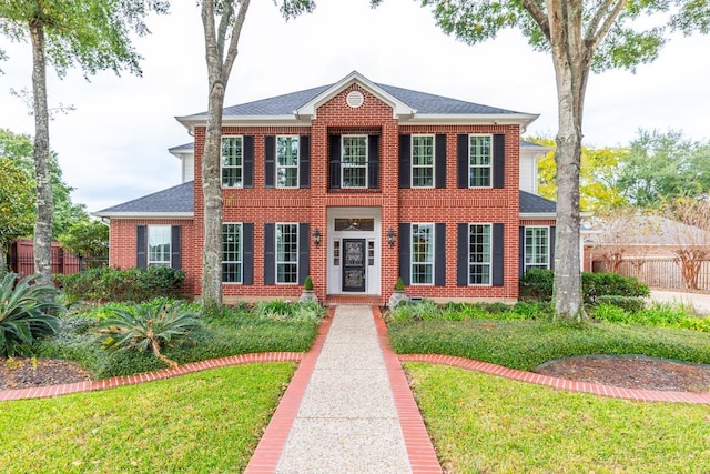 colonial-style house featuring a front lawn