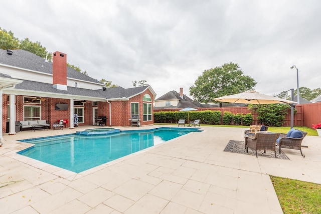 view of pool featuring an in ground hot tub, outdoor lounge area, a patio, and ceiling fan