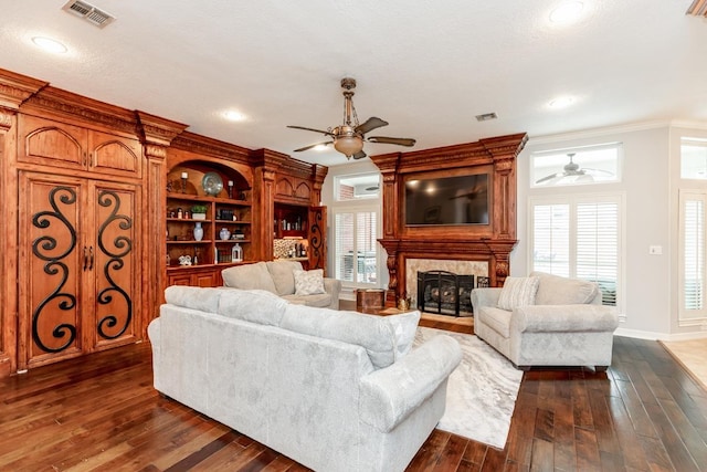 living room with a fireplace, dark wood-type flooring, ceiling fan, and ornamental molding