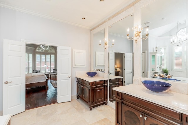 bathroom with ornamental molding, vanity, and a notable chandelier