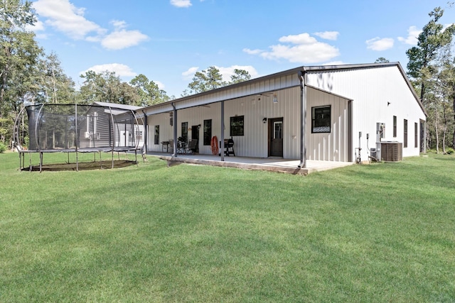 back of property with a yard, a patio, a trampoline, and central AC