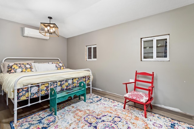 bedroom featuring hardwood / wood-style flooring, a wall mounted air conditioner, and an inviting chandelier