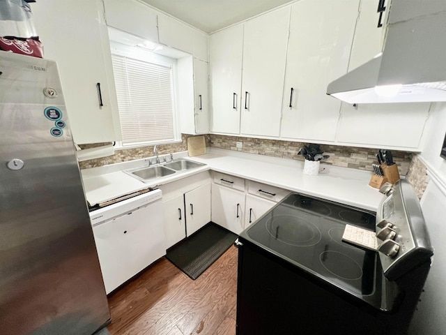 kitchen featuring dishwasher, sink, stainless steel fridge, range hood, and white cabinetry