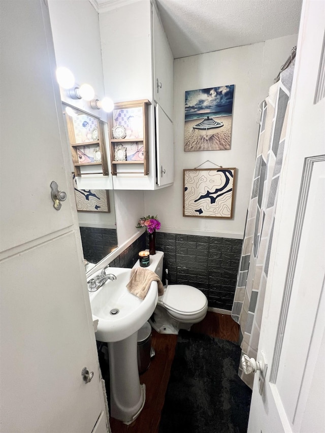 bathroom featuring toilet, a textured ceiling, and hardwood / wood-style flooring