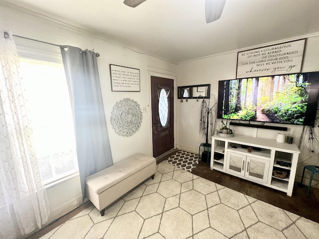 entryway with ceiling fan and crown molding