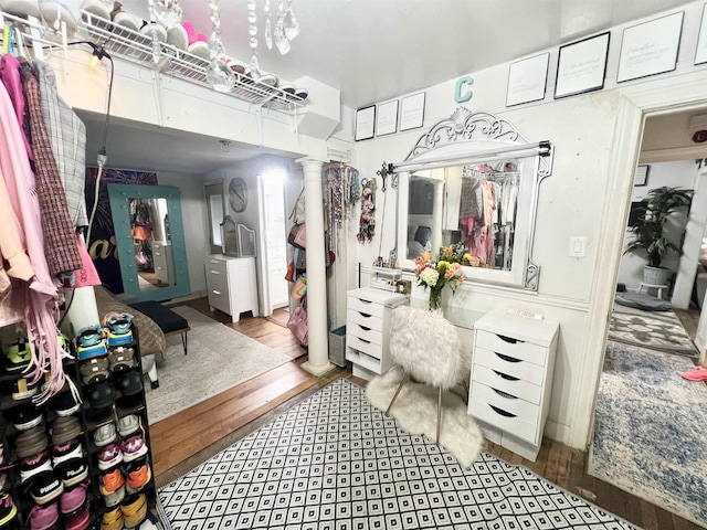 walk in closet with ornate columns and light hardwood / wood-style flooring