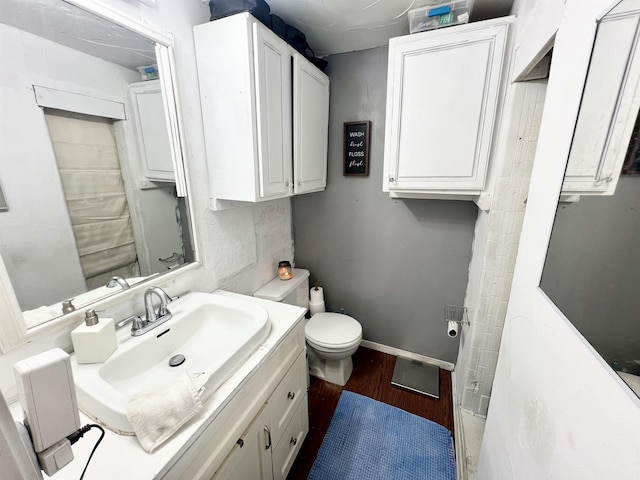 bathroom featuring wood-type flooring, vanity, and toilet