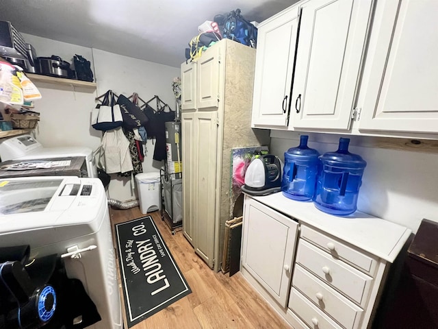 washroom with light hardwood / wood-style flooring, cabinets, and independent washer and dryer