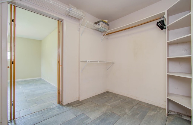 walk in closet with stone finish flooring