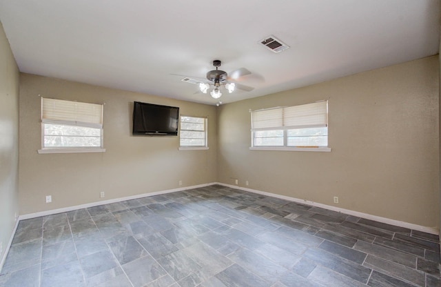 spare room with visible vents, baseboards, and a ceiling fan