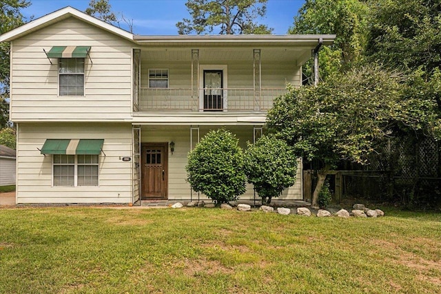 view of front of home featuring a balcony and a front lawn