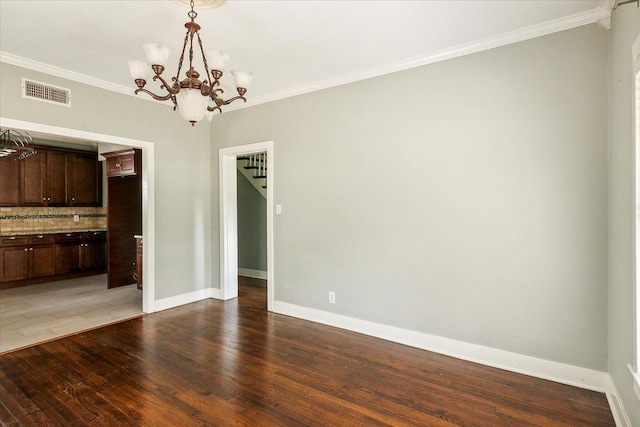 unfurnished dining area featuring crown molding, dark wood-type flooring, and a chandelier