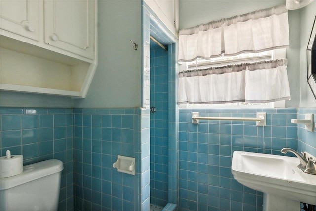 bathroom with sink, tile walls, and toilet