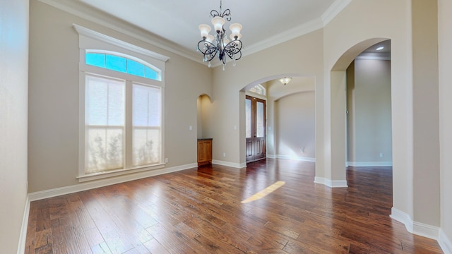 empty room with crown molding, dark wood-type flooring, and a chandelier