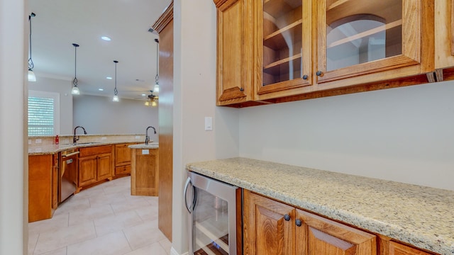 kitchen with wine cooler, sink, decorative light fixtures, dishwasher, and light stone countertops