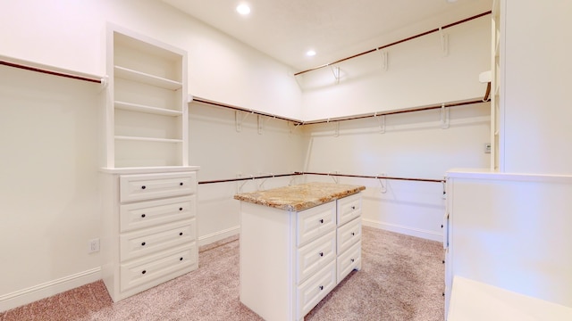 spacious closet featuring light colored carpet