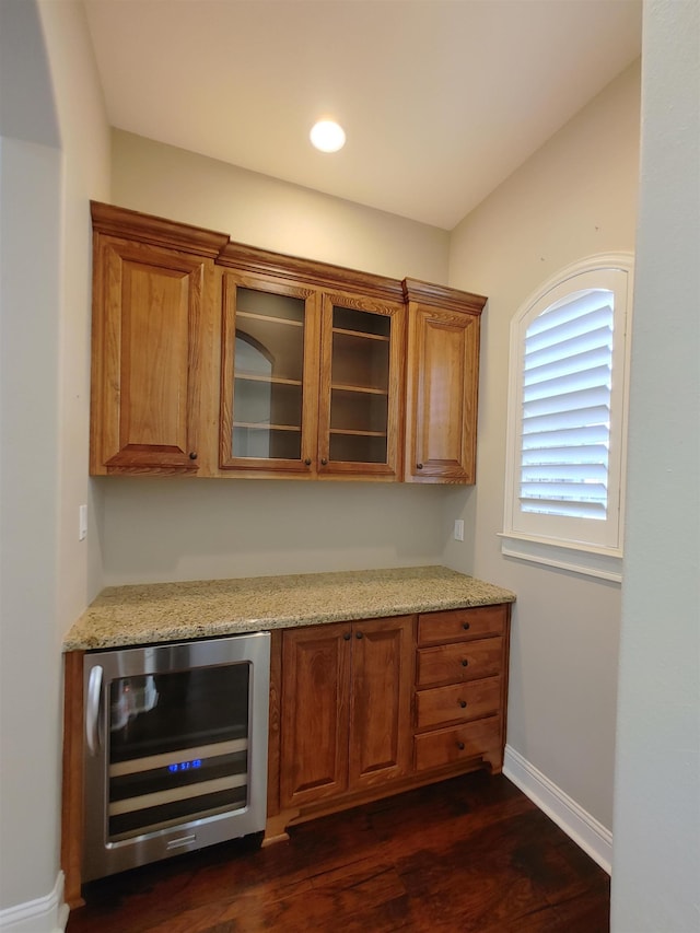 bar featuring wine cooler, light stone countertops, and dark hardwood / wood-style floors