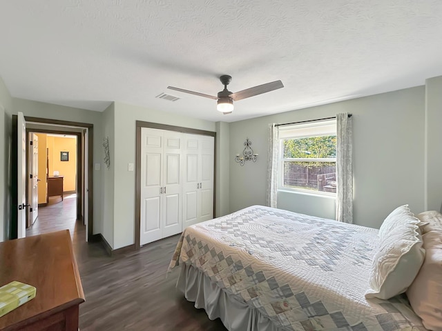 bedroom with dark hardwood / wood-style flooring, ceiling fan, a closet, and a textured ceiling