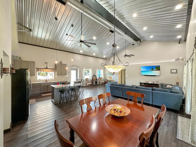 dining room with ceiling fan, dark wood-type flooring, and a high ceiling