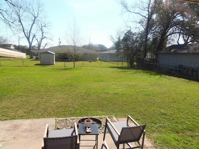 view of yard featuring a patio area, fence, and a fire pit