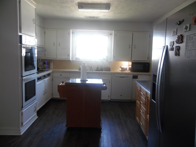 kitchen featuring dark wood-type flooring, a center island, white cabinetry, and black appliances