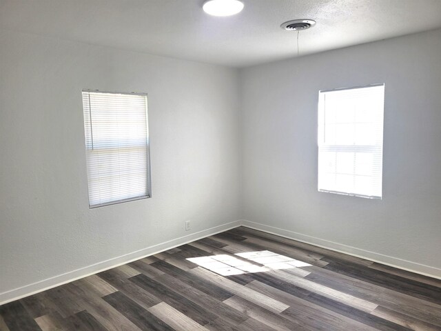 unfurnished room with dark hardwood / wood-style flooring