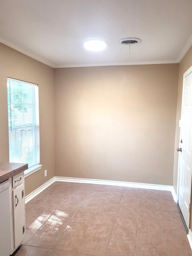 unfurnished dining area featuring a wealth of natural light, crown molding, and light tile patterned floors