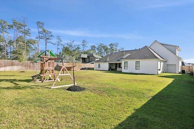 view of yard featuring a playground and a garage