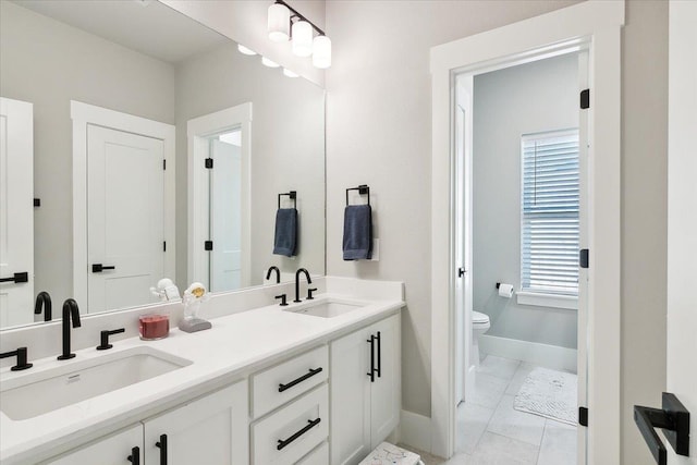 bathroom featuring tile patterned flooring, vanity, and toilet