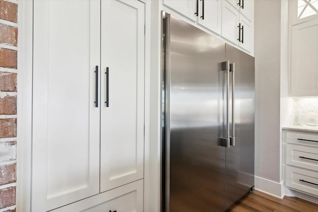 kitchen featuring built in fridge, white cabinets, and dark hardwood / wood-style floors