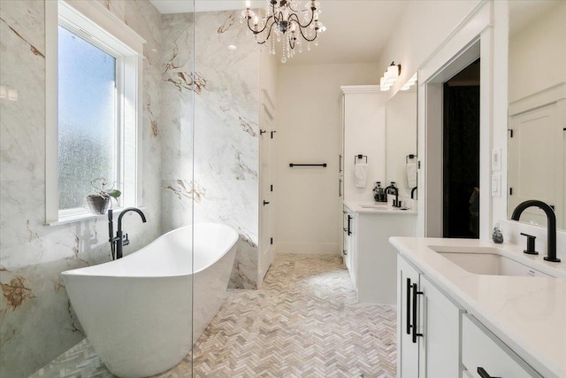 bathroom featuring vanity, a bathtub, a healthy amount of sunlight, and tile walls