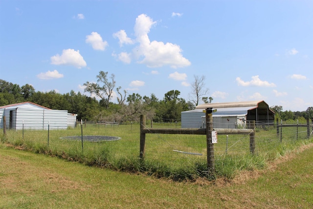 view of yard featuring an outbuilding, an outdoor structure, and fence