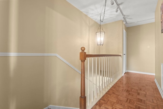 hallway featuring baseboards and an upstairs landing