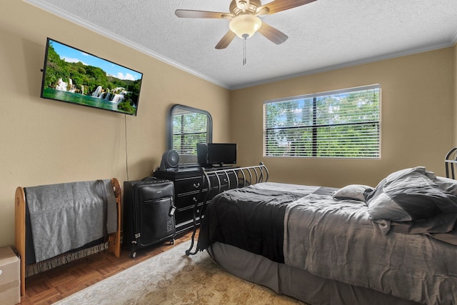 bedroom featuring a ceiling fan, ornamental molding, and a textured ceiling