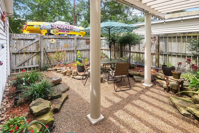 view of patio / terrace with outdoor dining space, a pergola, fence, and a gate