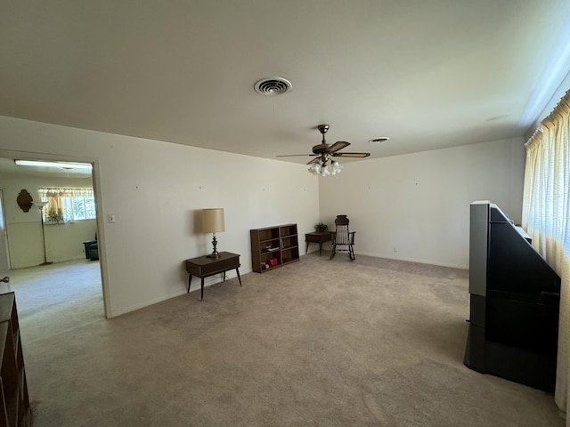 interior space with light carpet and ceiling fan