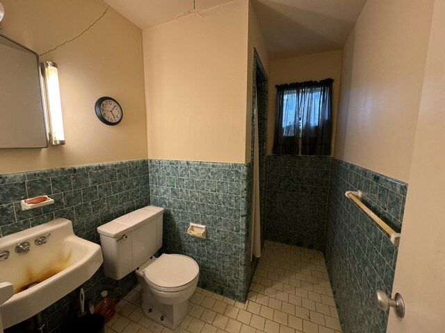 bathroom with tile patterned floors, sink, tile walls, and toilet