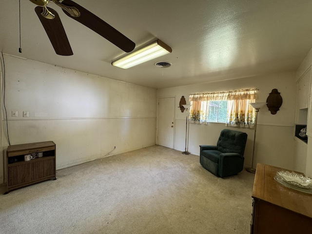 sitting room with ceiling fan and light carpet