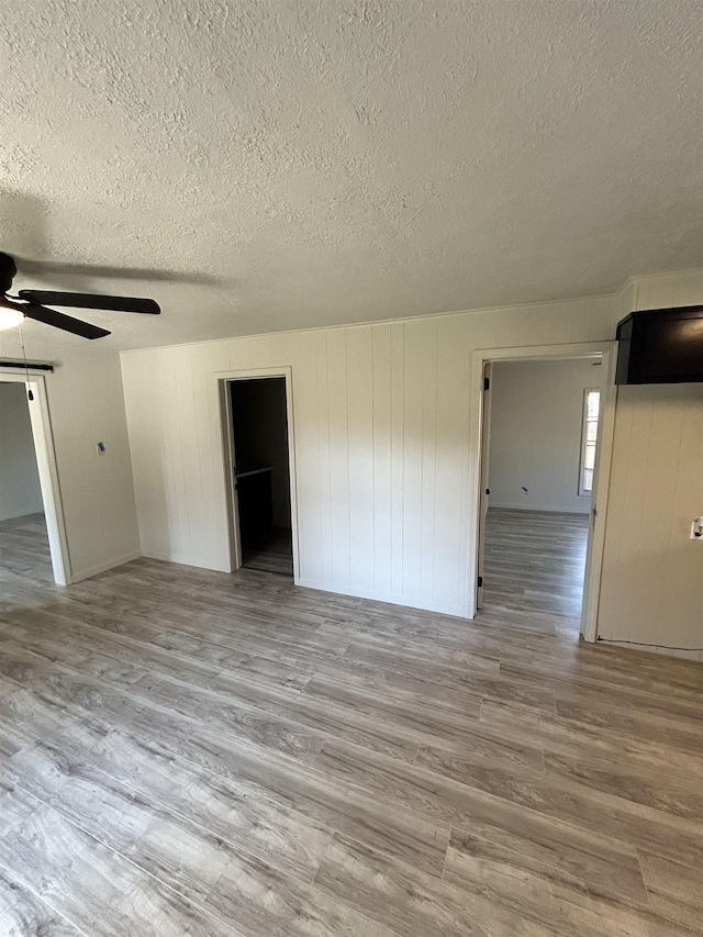 unfurnished room featuring ceiling fan, a textured ceiling, and light hardwood / wood-style floors