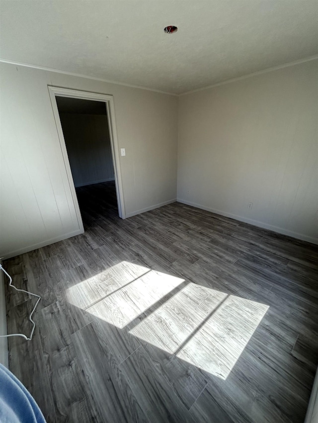 empty room featuring crown molding and dark hardwood / wood-style floors