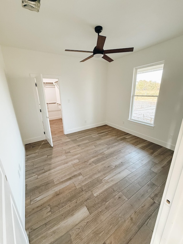 interior space with a closet, a spacious closet, ceiling fan, and light hardwood / wood-style floors