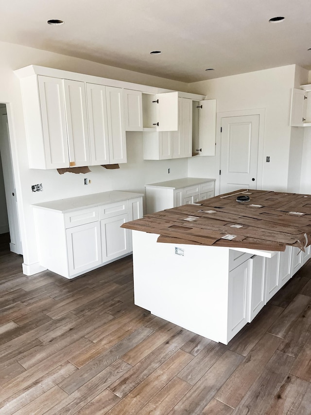 kitchen with a center island, dark hardwood / wood-style floors, and white cabinetry