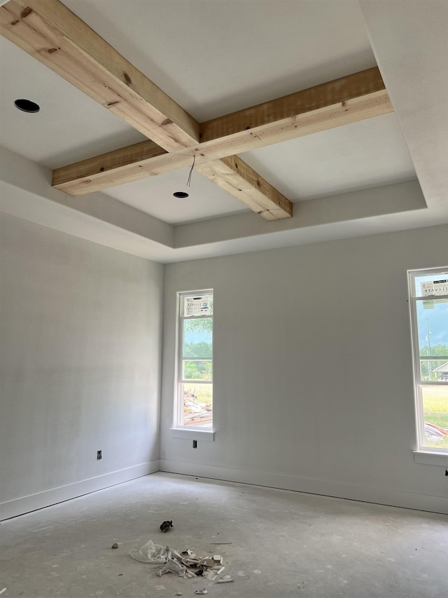 unfurnished room with beamed ceiling, a healthy amount of sunlight, and coffered ceiling