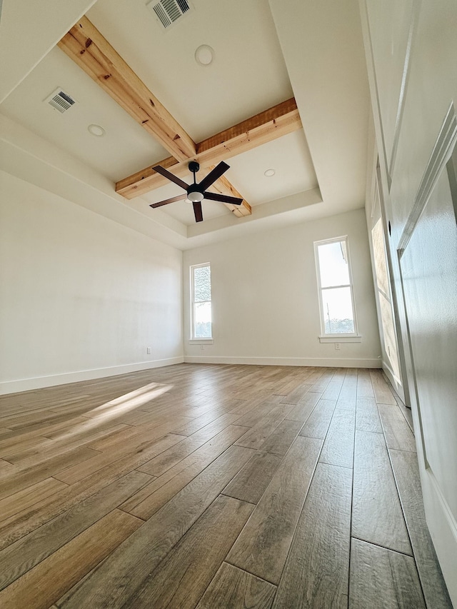 spare room with beam ceiling, ceiling fan, wood-type flooring, and coffered ceiling