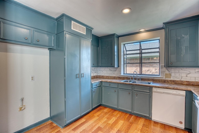 kitchen with backsplash, dishwasher, ornamental molding, light hardwood / wood-style flooring, and sink