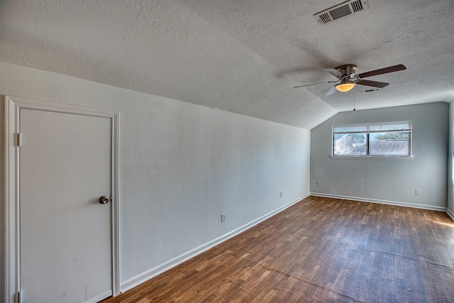 bonus room with vaulted ceiling, dark wood-type flooring, a textured ceiling, and ceiling fan