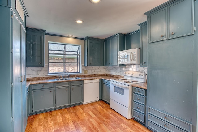 kitchen featuring white appliances, decorative backsplash, sink, light hardwood / wood-style flooring, and crown molding