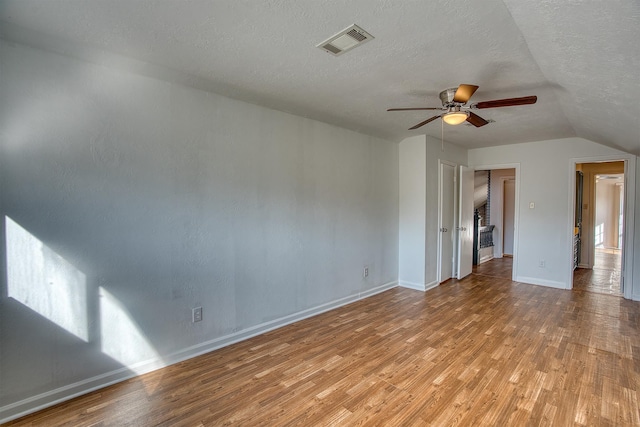 interior space with ceiling fan, a textured ceiling, light hardwood / wood-style flooring, and lofted ceiling