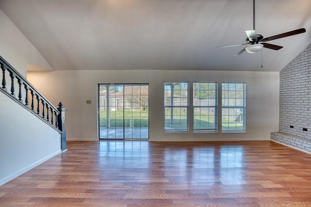 unfurnished living room with ceiling fan, wood-type flooring, and vaulted ceiling