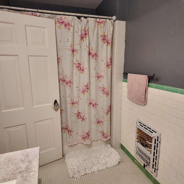 bathroom featuring tile patterned floors, a shower with curtain, and heating unit